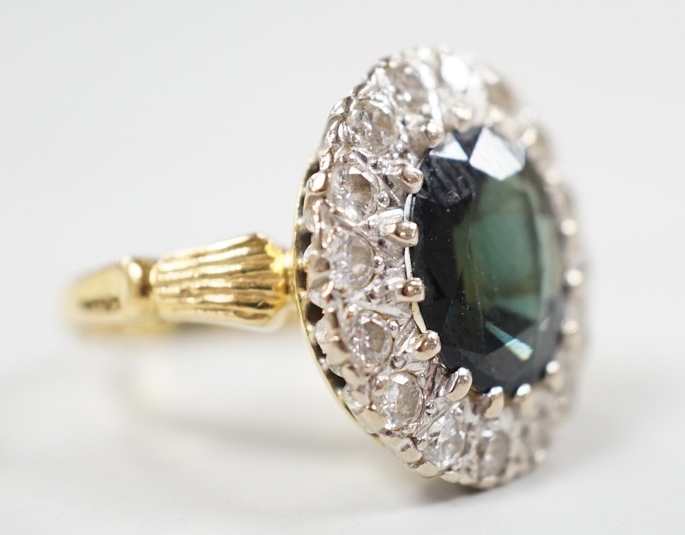 A 1970's? 18ct gold, single stone oval cut sapphire and illusion set diamond cluster ring, size O/P, gross weight 8.2 grams.